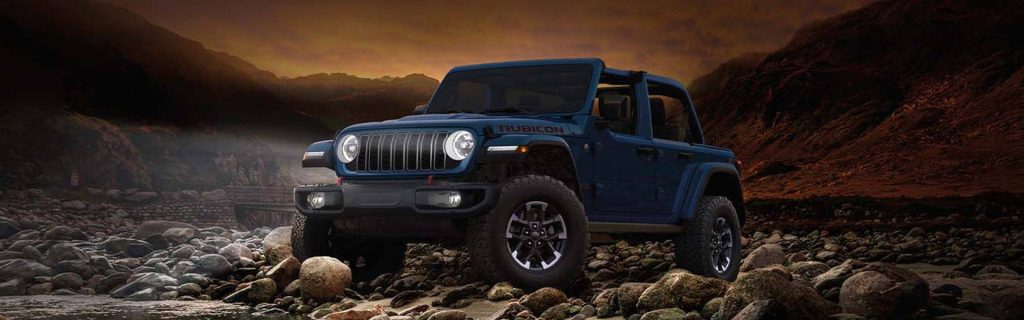 2026 Jeep Wrangler standing in a rocky region during sunset and showcasing its unique feature and design.