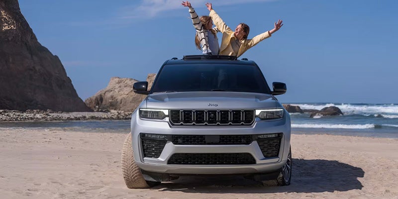 Family enjoying a Jeep SUV at the beach.
